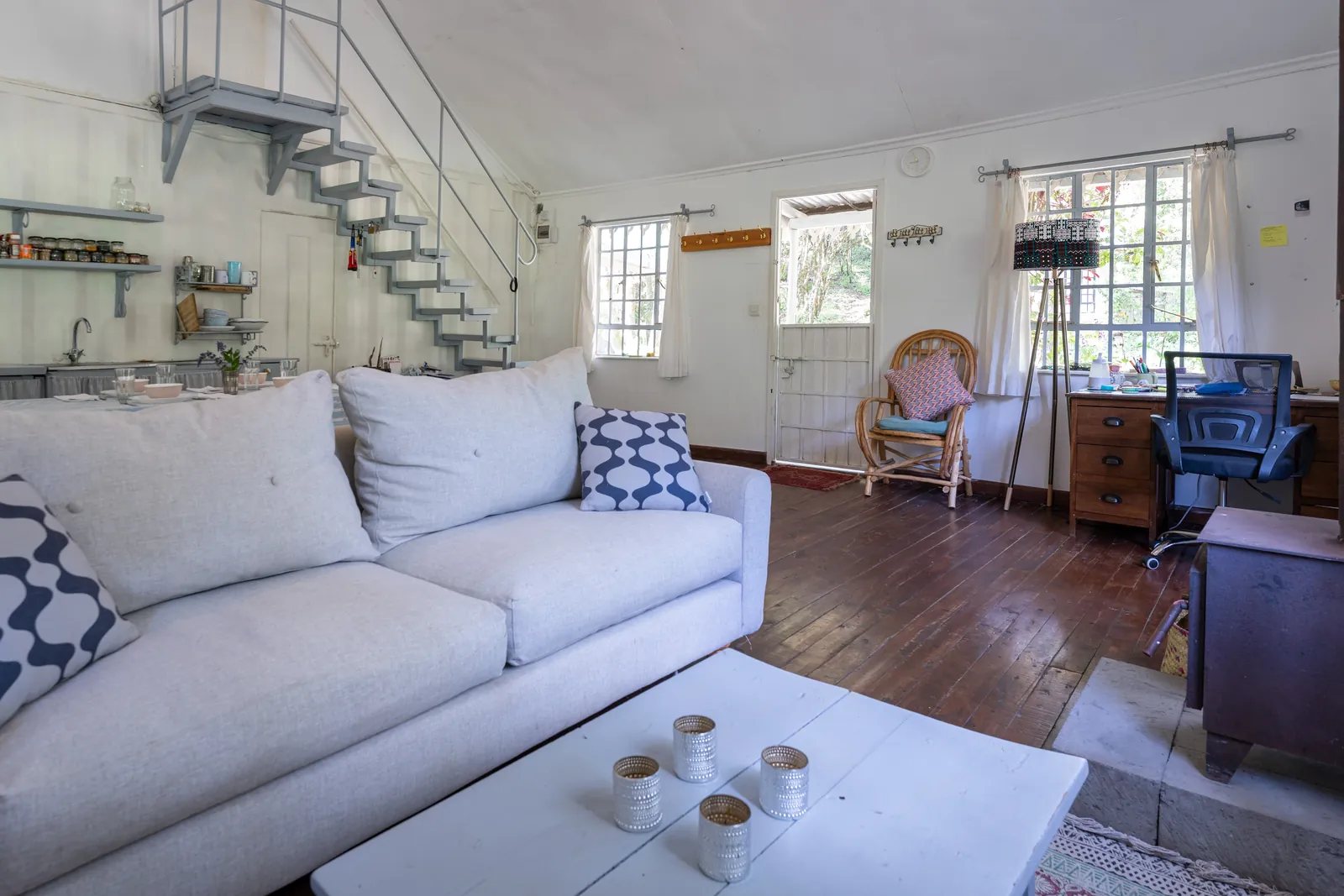 A sofa and low table in the light-filled living room at Gilgil Nest