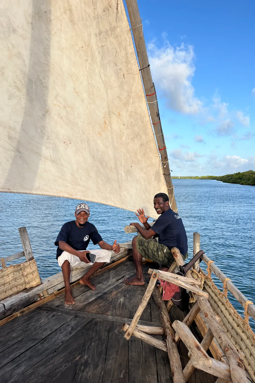 Sailing the Elsabella under full sail, with the coastline beyond