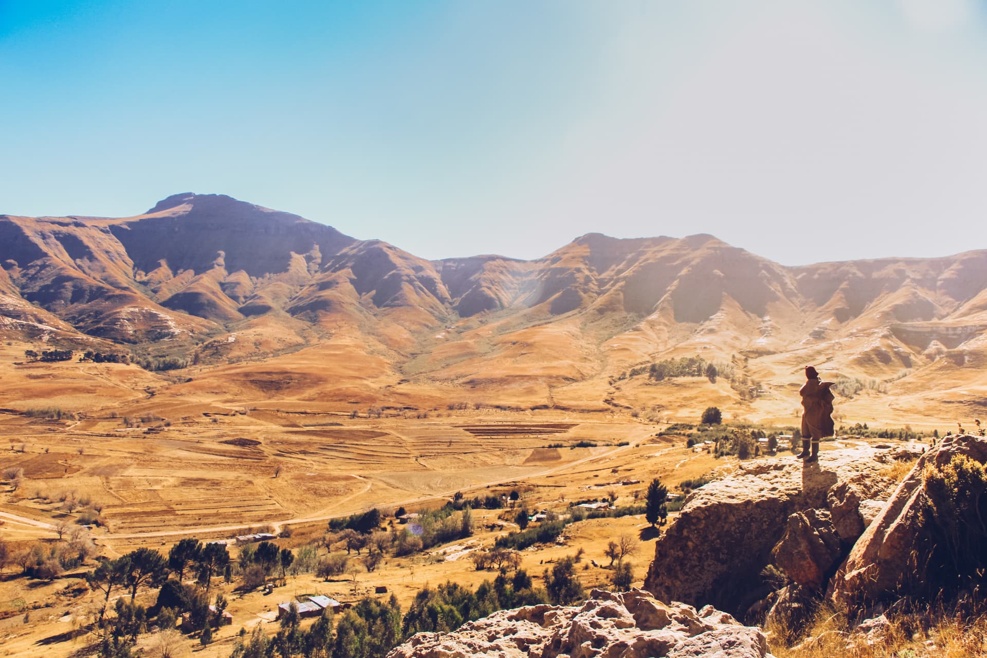 A man standing at a viewpoint looking out over the landscape