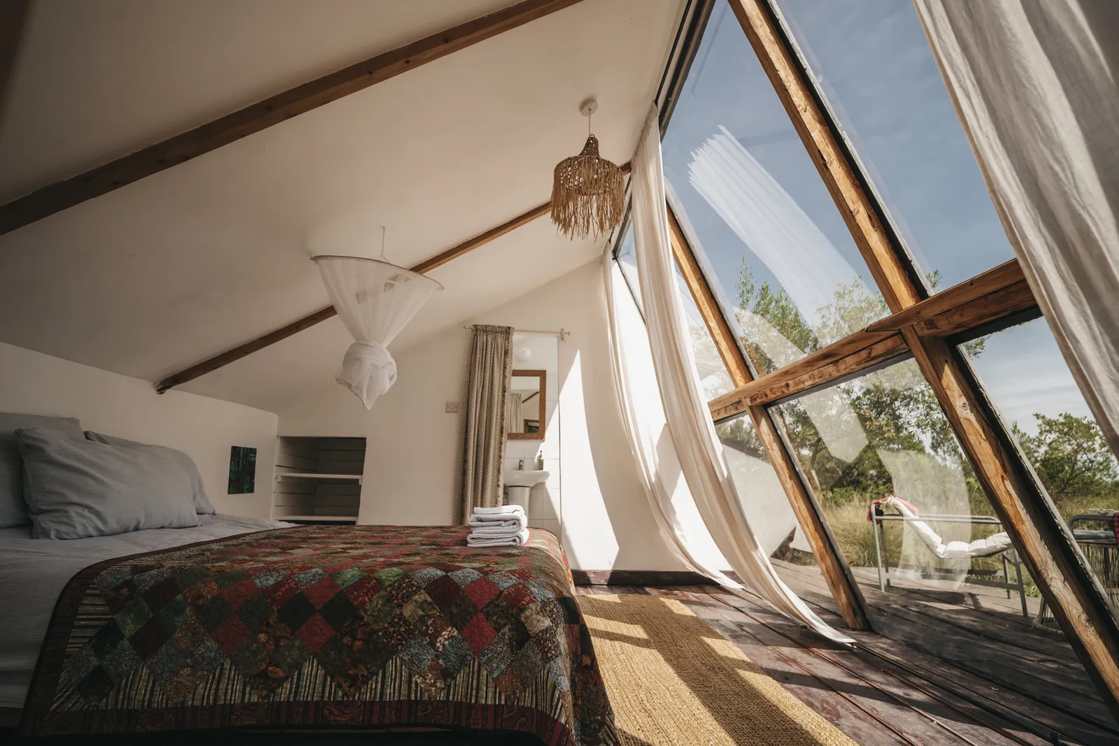 The bedroom at A-Frame Nest, looking out through the glass