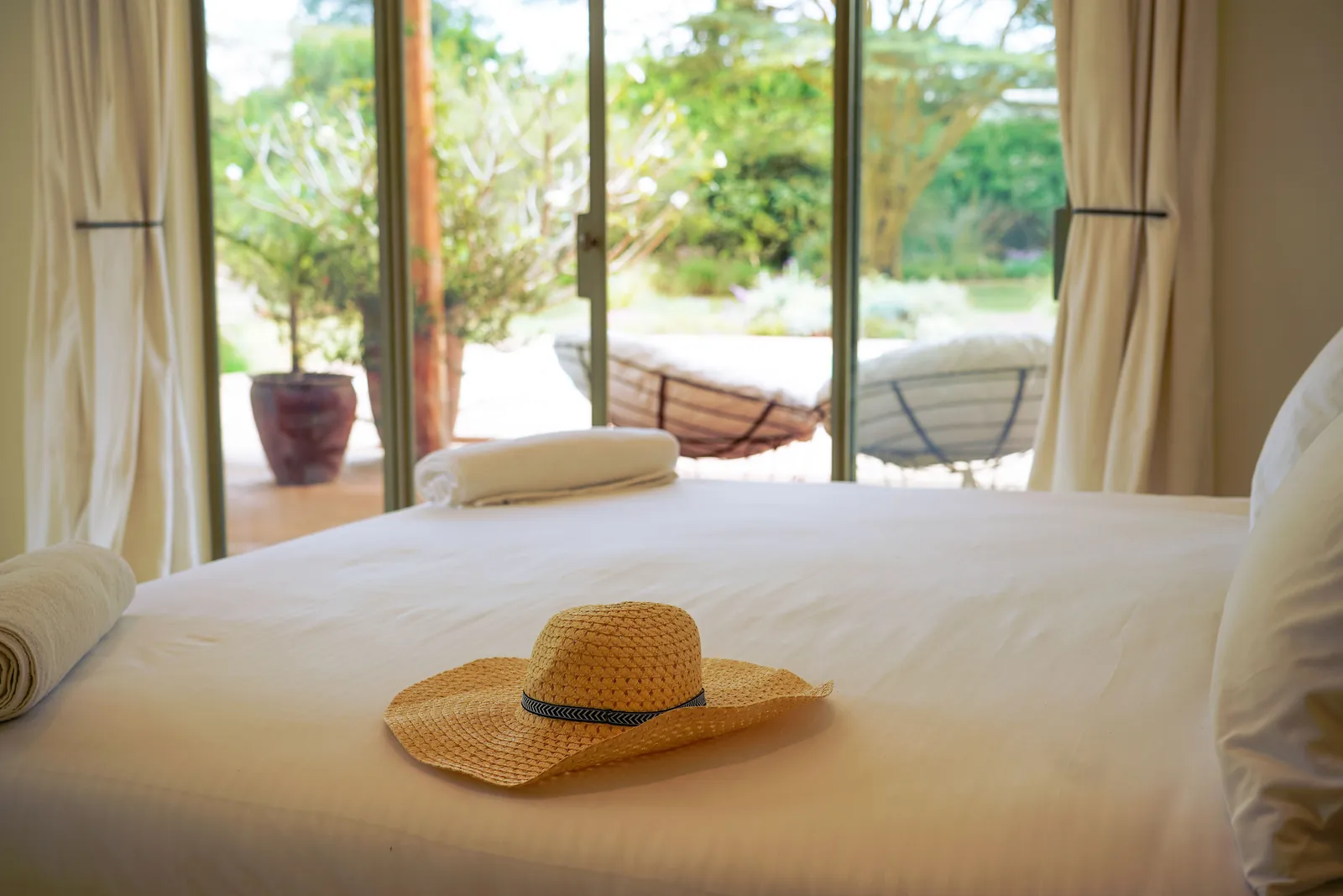 The main bedroom at Nairobi Pool Nest, with windows opening onto the trees