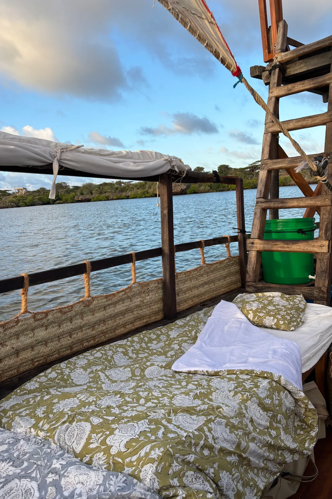 A bed made up on the deck of the Elsabella, moored close to the shore