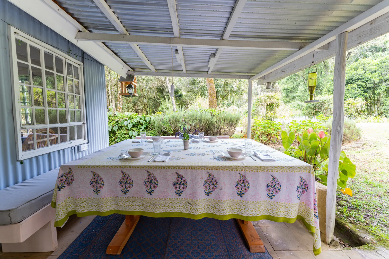 The long veranda table at Gilgil Nest, laid with bowls and a block-printed cloth under the tin roof