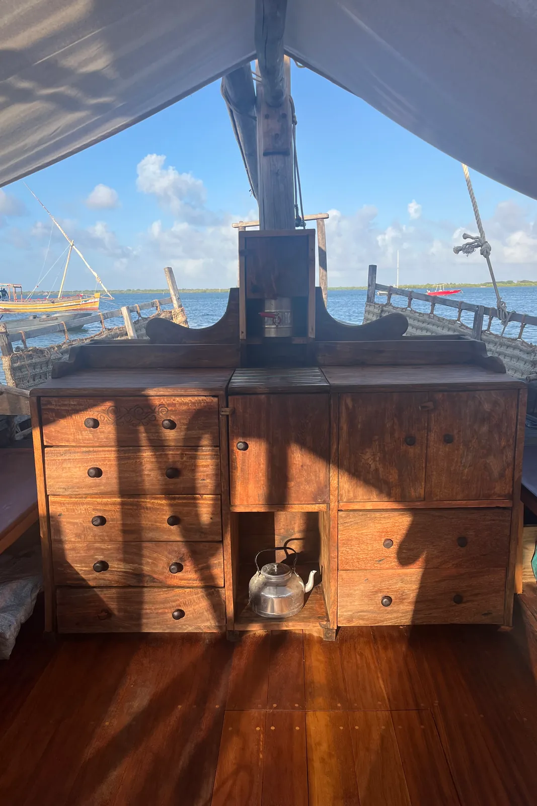 The wooden deck of the Elsabella beneath its shade canopy, looking forward to the mast