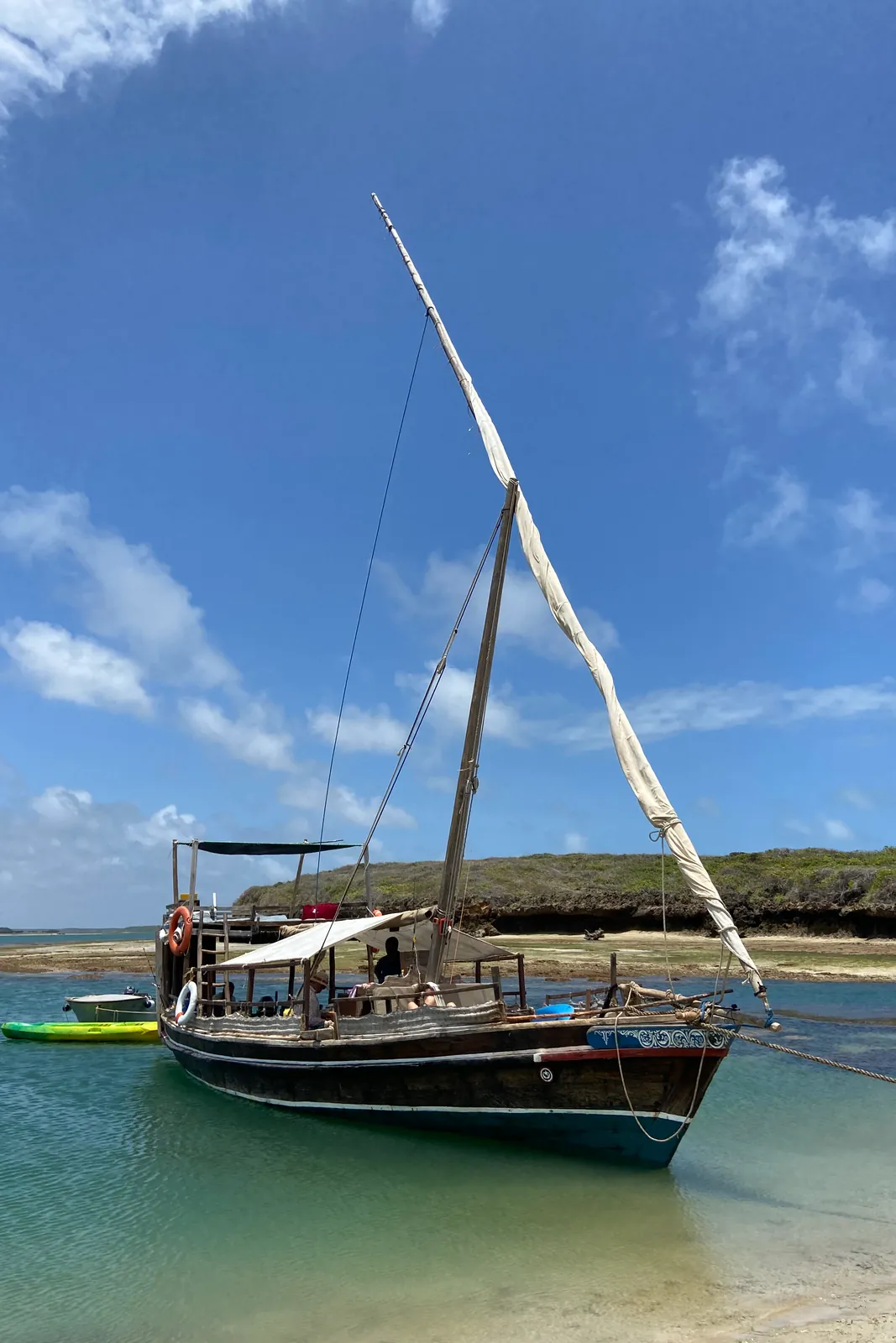 The Elsabella dhow at anchor in shallow turquoise water off a sandbank near Lamu