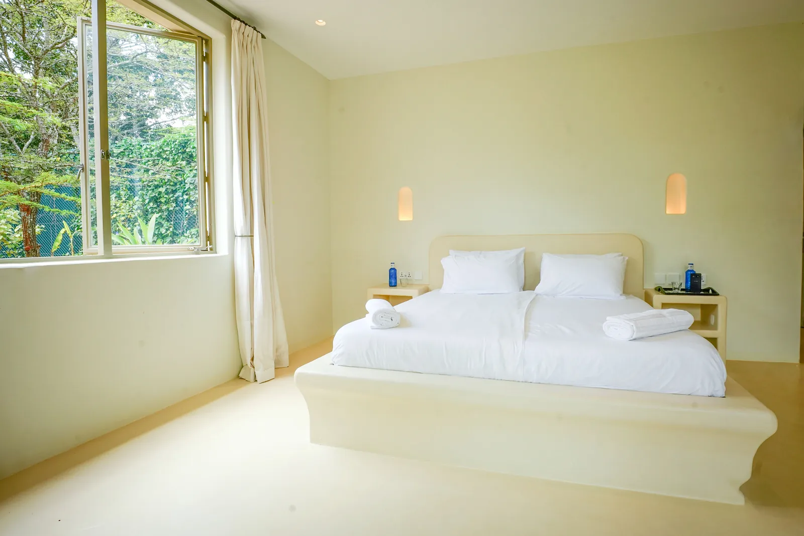 The second bedroom at Nairobi Pool Nest, with tall windows and white linen