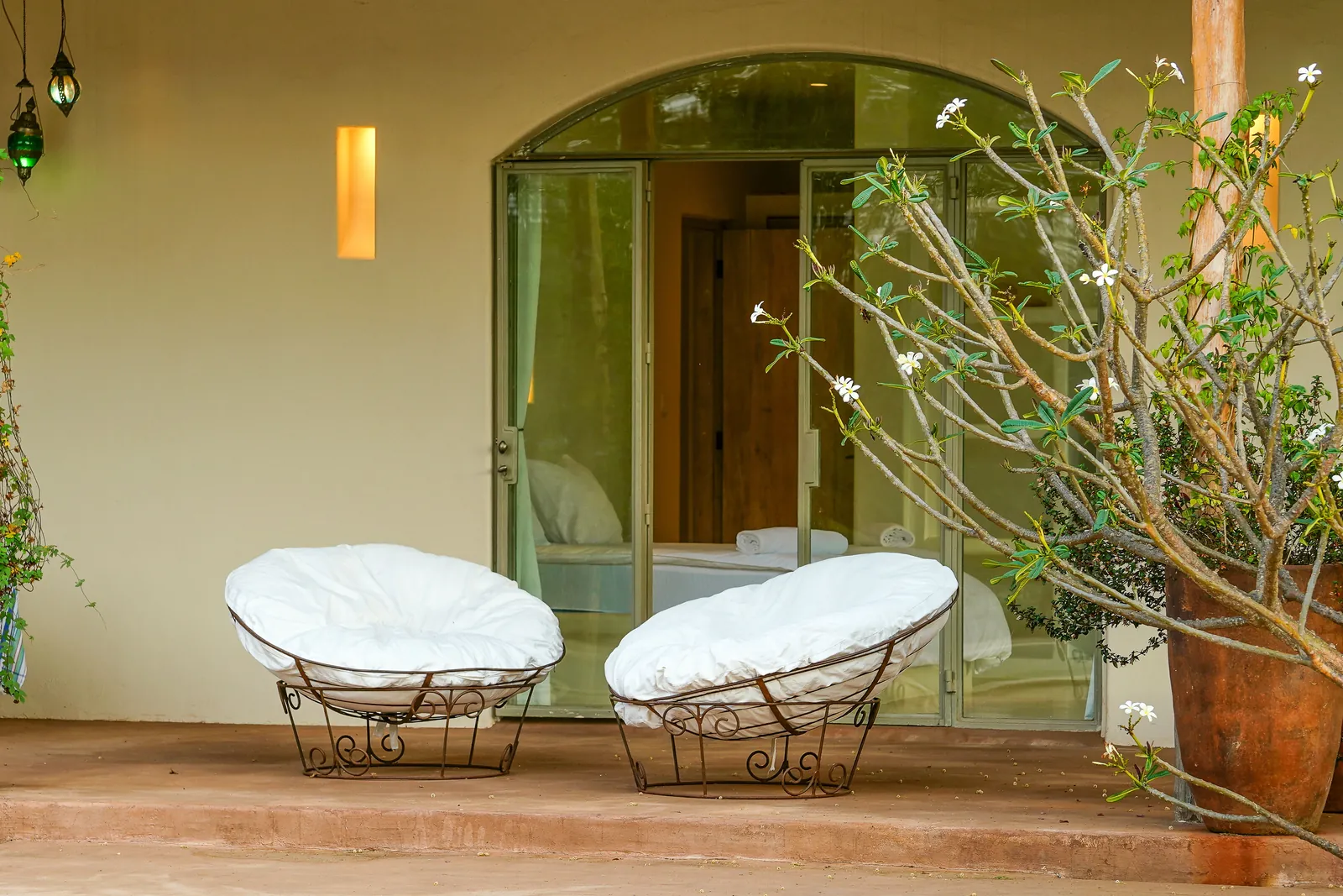 Two low chairs beside an arched window at Nairobi Pool Nest