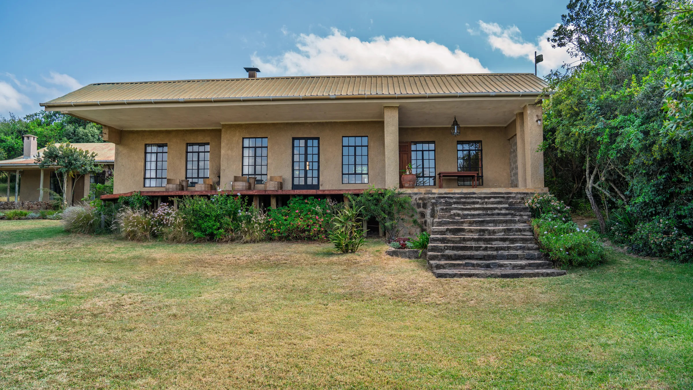 Asili Cottage and its verandah steps, seen from the lawn