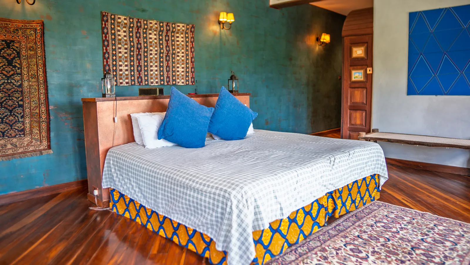 A bedroom at Asili House with teal walls and blue cushions