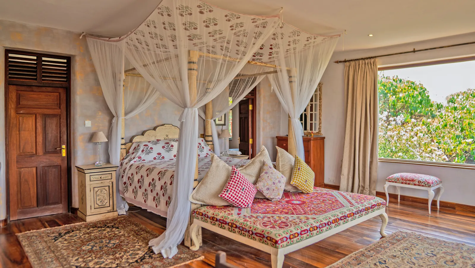 A four poster bed under white nets at Asili House